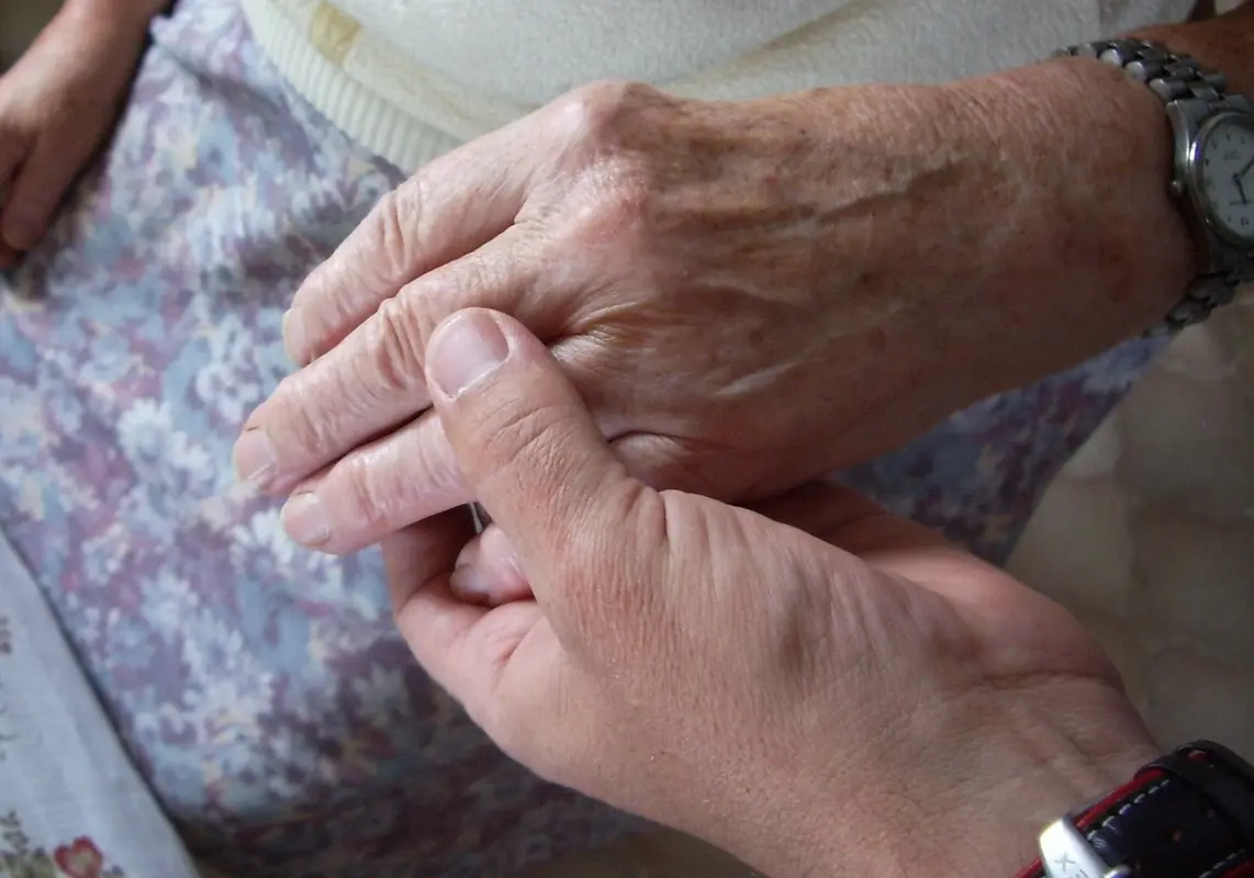 Junge Hand hält die Hand einer älteren Frau