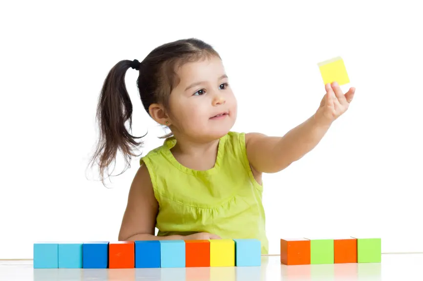 child plays with building blocks and learning of colors